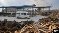 An ambulance returns after handing over the body of a victim who died of the Covid-19 coronavirus at an open air crematorium in Bangalore on May 8, 2021.