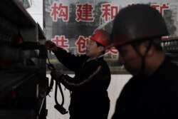 FILE - Workers put away equipment after coming out of the Datai coal mine in Mentougou, west of Beijing, Jan. 8, 2020.
