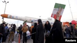 People are seen gathered around a model of Simorgh satellite-carrier rocket displayed during a ceremony marking the 37th anniversary of the Islamic Revolution, in Tehran, Iran, Feb. 11, 2016. 