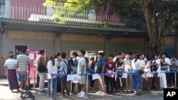 FILE - People wait in line to enter into the Thai Embassy for visa appointments in Yangon, Myanmar, Feb. 20, 2024. Crowds of people have thronged to get passports and visas to neighboring Thailand after Myanmar activated a conscription law.