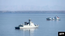 Kapal perusak dengan peluru kendali milik Tentara Pembebasan Rakyat China Baotou (133) (kiri) berlayar dalam latihan gabungan antara Iran, Rusia, dan China di Teluk Oman dalam foto yang dirilis pada 10 Maret 2025. (Foto: Iranian Army Office/AFP)