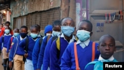 Schoolchildren queue to have their temperature checked before entering the Olympic Primary School during the reopening of schools, after the government closed learning institutions due COVID-19 outbreak, in Kibera slums of Nairobi, Jan. 4, 2021.