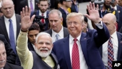 FILE - Indian Prime Minister Narendra Modi and U.S. President Donald Trump walk the perimeter of the arena floor to greet attendants after Modi's speech during the "Howdi Modi" event on Sept. 22, 2019, at NRG Stadium in Houston, Texas.