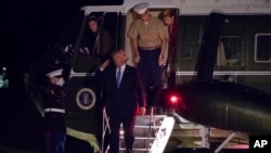 President Donald Trump salutes as he steps off of Marine One on this return to the White House in Washington, Sunday, Aug. 20, 2017.