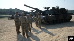 2024年8月14日美國軍人站在M1A2艾布拉姆斯坦克旁，準備參加在南韓抱川羅德里格斯實彈演習。