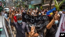 Anti-coup protesters flash the three-finger salute of defiance during a demonstration in Yangon, Myanmar on April 27, 2021.