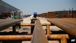 FILE - Jose Mata grinds a steel pipe at the Borusan Mannesmann plant in Baytown, Texas, April 23, 2018. The U.S. Chamber of Commerce issued a report Monday that argued tariffs imposed by Washington and retaliation by its partners would boomerang badly on the American economy.