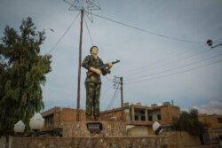 A statue of a female fighter symbolizes some of the stated goals of the Kurdish-led region: a semi-autonomous territory that expects equality, in Darbasiyah, Syria, Oct. 22, 2019. (VOA/Yan Boechat)
