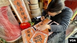 80後的香港博客阿金與上環老店朱榮記合作，設立手寫揮春檔，傳承香港特色揮春文化。( 美國之音粵語組）