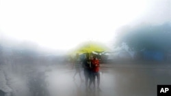 People walk in the rain in Port-au-Prince on 05 Nov 2010.