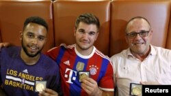 Anthony Sadle dan Aleck Sharlatos dari AS dan Chris Norman dari Inggris (kiri ke kanan) yang membantu mencegah serangan teroris di Perancis memperlihatkan medali mereka di Arras, Perancis (21/8). (Reuters/Pascal Rossignol)