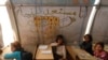 FILE - Children attend a class inside a makeshift school in the Bab al-Salam refugee camp in Azaz, Syria, Oct. 27, 2014.