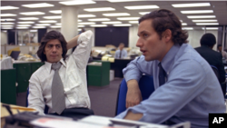 FILE- Reporters Bob Woodward, right, and Carl Bernstein, whose reporting of the Watergate case won them a Pulitzer Prize, sit in the newsroom of The Washington Post in Washington, May 7, 1973.