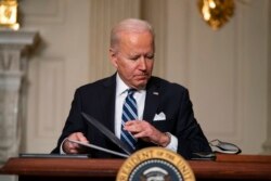 FILE - President Joe Biden signs a series of executive orders on climate change, in the State Dining Room of the White House in Washington, Jan. 27, 2021.
