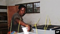 A voter casts her vote at a polling station in Burundi's capital, Bujumbura, 23 July 2010