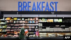 นักช็อปหยิบเบคอนระหว่างซื้ออาหารในซูเปอร์มาร์เก็ต เมื่อ 14 ส.ค. 2025 ในแคลิฟอร์เนีย (Photo by Frederic J. BROWN / AFP)