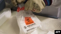 Photo released by the World Health Organization on October 22, 2014 shows reception by Geneva University Hospital (HUG) of a batch of experimental rVSV Ebola vaccine developed at the National Microbiology Laboratory in Winnipeg, Canada.