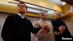 Occupy Central civil disobedience founder Benny Tai (C), a law professor at the University of Hong Kong, along with co-founders Chan Kin-man (L), a professor of sociology at Chinese University and Reverend Chu Yiu-ming, join hands during a news conference