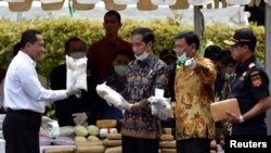 FILE - FILE - Indonesian President Joko Widodo (C) and other officials prepare to destroy illegal narcotics during an event in Jakarta, Indonesia, Dec. 6, 2016.