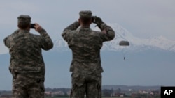 FILE - U.S Army soldiers of the 2nd Squadron, 38th Cavalry Regiment, part of the NATO-led peacekeeping mission in Kosovo watch fellow soldiers during a training exercise at U.S military base Camp Bondsteel, near the village of Sojeve in Kosovo, April 15, 2014.