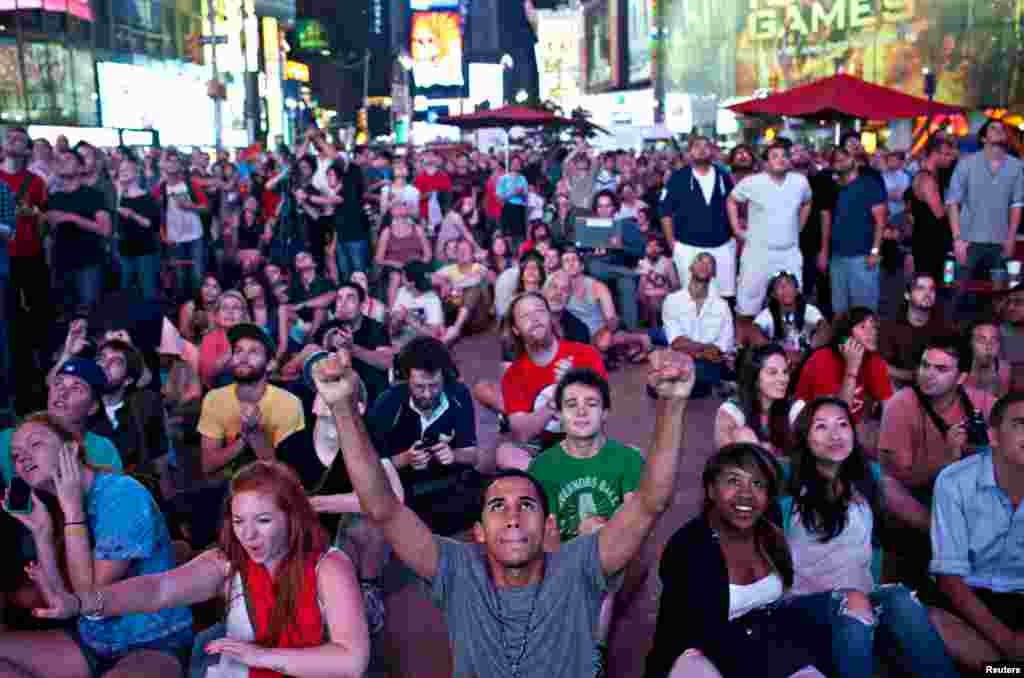 Xavier Cabrera (front, C) of New York, celebrates while watching a live broadcast of the NASA Mission Control center in Time Square, in New York, August 6, 2012. 