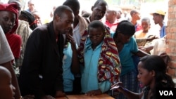 FILE - Burundian refugees register with officials at a Bugesera reception to enter Eastern Rwanda. (M.Yusuf/VOA)