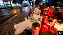 Teddy bears were left together with candles near the Christmas market, where a car drove into a crowd on Friday evening, in Magdeburg, Germany, Dec. 22, 2024. 