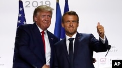 FILE - U.S. President Donald Trump, left, and French President Emmanuel Macron shake hands after their joint press conference at the G-7 summit, in Biarritz, France, Aug. 26, 2019.