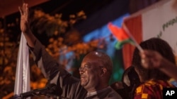 FILE - Roch Marc Kabore, winner of Burkina Faso's presidential election, celebrates as supporters gather outside his campaign headquarters in Ouagadougou, Dec. 1, 2015.