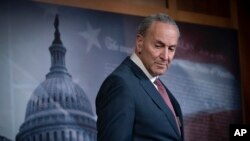 FILE - Senate Minority Leader Chuck Schumer pauses as he speaks to reporters, Jan. 31, 2020. 