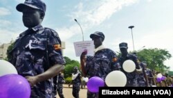 Ugandan police hold balloons and signs condemning violence against women, Kampala, Uganda, Dec. 5, 2015.