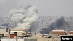 Asap mengepul pasca serangan pasukan Irak atas posisi ISIS di Mosul (25/6). 