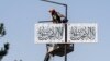 Seorang pekerja memasang bendera Taliban di sepanjang jalan di ibu kota Kabul (13/8). Rezim Taliban Afghanistan menyatakan 15 Agustus sebagai hari "kemenangan" melawan AS. 