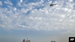 FILE - A speedboat and a helicopter of the Iran's Revolutionary Guard move around a British-flagged oil tanker Stena Impero, which was seized by the Guard, in the Iranian port of Bandar Abbas, July 21, 2019. 