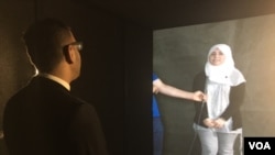 Mohannad Jaber in New York talks to Syrian refugee Zad in Zaatari camp, Jordan, via portal. (M. Besheer/VOA)