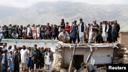 FILE - People search for victims after floods in Charikar, capital of Parwan province, Afghanistan, Aug. 27, 2020.