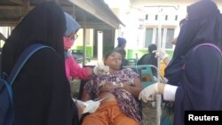 A paramedic gives treatment to an earthquake survivor outside a hospital in Donggala, Indonesia, Sulawesi Island, Sept. 28, 2018.