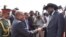 Sudanese President Omar al Bashir is greeted as he arrives in Juba for a historic visit on Friday, April 12, 2013 with a handshake by his South Sudanese counterpart Salva Kiir. as 