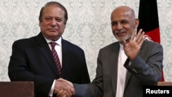 Afghan President Ashraf Ghani (R) shakes hands with Pakistani Prime Minister Nawaz Sharif after a news conference in Kabul, May 12, 2015. 