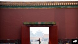 A visitor wearing a face mask to protect against the new coronavirus walks through the Forbidden City in Beijing, May 1, 2020. The Forbidden City reopened on Friday, China's May Day holiday, to limited visitors.
