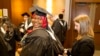 Mariama Bassama is helped with her hood by Charlotte Pandraud before the 2016 graduation ceremony for Hult International Business School, in Boston.