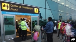 Passengers stand at a distance and wear masks amid the COVID-19 pandemic as they wait in line to check in at the Jorge Chávez International Airport in Callao, Peru, July 15, 2020.
