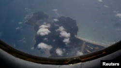 A Vietnam Air Force aircraft AN-26 flies over Con Dao island during a mission to find the missing Malaysia Airlines flight MH370, March 12, 2014.