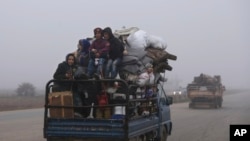 Civilians ride in a truck as they flee Maaret al-Numan, Syria, ahead of a government offensive, Monday, Dec. 23, 2019.