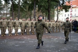 FILE - General Jaroslaw Mika marches before U.S. soldiers during the welcome ceremony at the Polish military base in Zagan, Poland, Jan. 12, 2017.