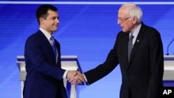 Mantan Walikota South Bend, Indiana, Pete Buttigieg (kiri) dan Senator Vermont Bernie Sanders berjabat tangan sebelum debat Capres Partai Demokrat 7 Februari lalu. 