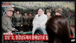 A woman watches a news program reporting North Korea's firing unidentified projectiles with a file image of North Korean leader Kim Jong Un, in Seoul, South Korea, Nov. 28, 2019.