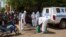 Health workers put on protective gear outside a mosque before disinfecting it, in Bamako, Mali, Nov. 14, 2014.