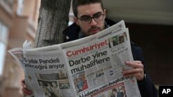 A man reads Cumhuriyet newspaper outside its Ankara office after Turkish police detained the chief editor and at least eight senior staff of Turkey's opposition newspaper, Oct. 31, 2016. The headline reads: "The coup against opposition again."