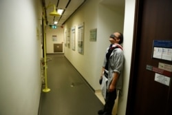 A protester rests against a wall as he searches a building for fellow protesters who might be hiding, at the Hong Kong Polytechnic University in Hong Kong, Nov. 22, 2019.